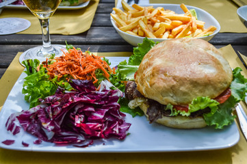 hamburger, salad, french fries and beer - dinner close up