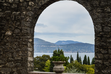 view of Lake Garda through a stone arch window - Italy