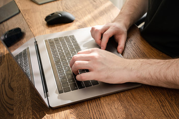 Fototapeta premium Man typing on laptop keyboard. Working from home.
