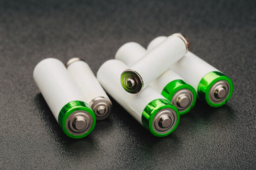 Close the positive poles of the used battery on a black background.