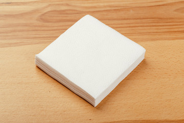white paper napkin or tissue on the wooden table background.