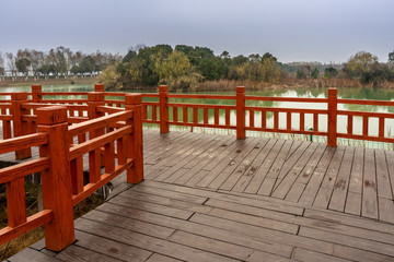 Fototapeta na wymiar Wooden bridge over little river in city park