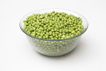 Fresh green peas in a glass bowl isolated on white background