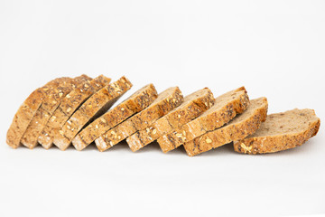 Slices of fresh loaf with cereals laying together. Sliced bread with seeds made of rye flour isolated on white background. Studio shot. Selective focus. Side view. Cooking and baking at home concept