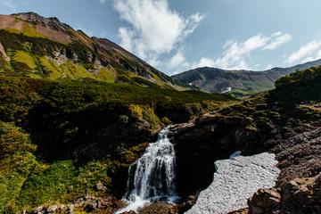 Fototapeta na wymiar Waterfall in the mountain range. Kamchatka