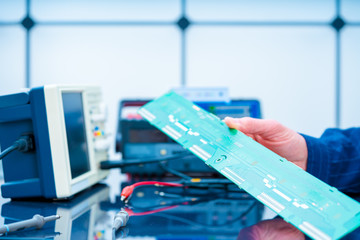 Fototapeta premium Debugging electronics device. PCB witch microcontroller in electronics laboratory