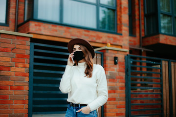 young woman with mobile phone in the city in mask. coronavirus. covid-19.  