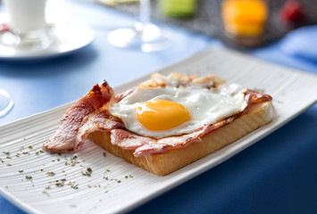 Fried egg and bacon toast for english breakfast set table