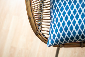 Natural rattan dining armchair on a wooden floor, rustic accent at the modern living room, close up shot 
