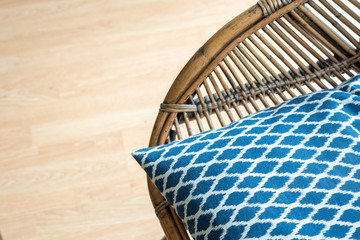 Obraz premium Natural rattan dining armchair on a wooden floor, rustic accent at the modern living room, close up shot 