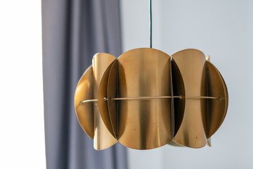 Modern lamp in a loft room, against background of concrete wall, black and gold 