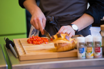 Man Cutting  Cherry Tomatoes and Preparing a Meal on Wooden Chopping Board