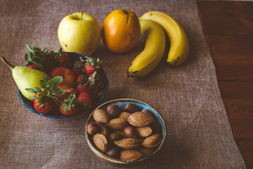 Frutas frescas de estación y frutos secos en vasijas de terracota y platos de ceramica de colores