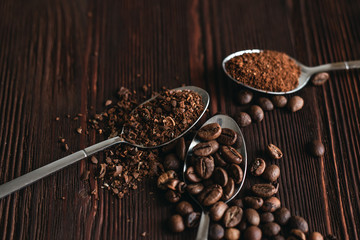Roasted black coffee beans of different fractions on a dark table
