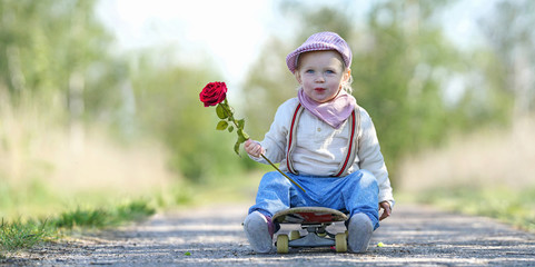kleines Mädchen lachend mit Rose