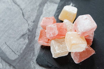 Turkish sweets (Turkish delight) of different colors in powdered sugar