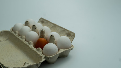 White eggs in tray on the left side of the frame. Free place on right side