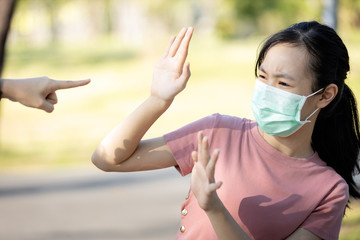 Problems of bullying at school,sad stressed asian girl student in medical mask,hand pointing finger...