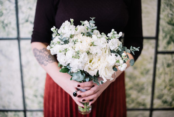 Very nice young woman holding big beautiful blossoming mono bouquet of fresh white matthiola flowers