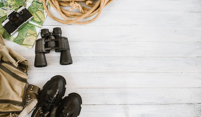 Top view of travel accessories for a mountain trip on white wooden background, flatlay, copy space - 348537416