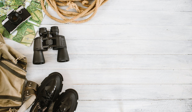 Top view of travel accessories for a mountain trip on white wooden background, flatlay, copy space