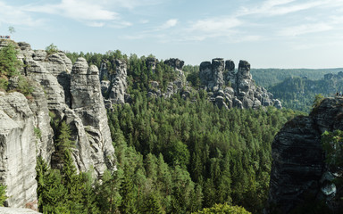 Fototapeta na wymiar View from viewpoint of Bastei in Saxon Switzerland, Germany, Dresden to the on the rocks at sunrise, National park Saxon Switzerland. Background. Wallpaper.