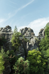 Fototapeta na wymiar Wallpapers for your phone. Bridge Bastei in Saxon Switzerland, on a sunny day with a beautiful sky near the river Elbe View from the viewpoint in Saxon Switzerland Germany, view of bridge. Vertical.