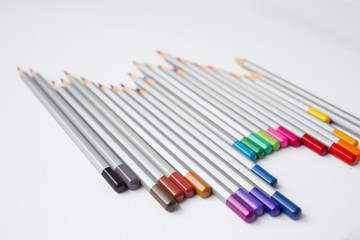 A colorful pencils in the white canvas background. Drawing by pencils. Hobby during quarantine. Selective focus. Inspiration, talent. Creating a new picture, sketch. An artist. Art.