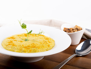 Mixed vegetable cream soup in a white bowl, isolated on a white background, on wooden cutting board