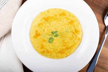 Mixed vegetable cream soup in a white bowl, isolated on a white background, on wooden cutting board