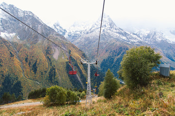 Old chairlift cableway in Dombay ski resort from the Mount Mussa Achitara in autumn, beautiful mountains landscape, snowy peaks, Caucasus, Russia