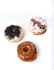 Three melted glazed with dark and white chocolate, marshmallows, biscuit crumbles, caramel sugar