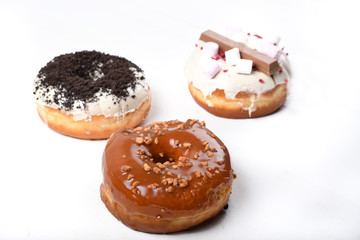 Three melted glazed with dark and white chocolate, marshmallows, biscuit crumbles, caramel sugar