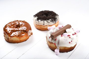 Three melted glazed with dark and white chocolate, marshmallows, biscuit crumbles, caramel sugar