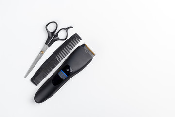 hair clipper, scissors and comb on a white background