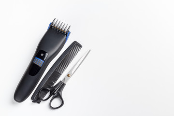 hair clipper, scissors and comb on a white background