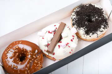 Three melted glazed with dark and white chocolate, marshmallows, biscuit crumbles, caramel sugar