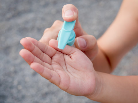 Child hand with sanitizer gel bottle for corona virus, covid-19 protection, cleaning hand, pressing by father hand.