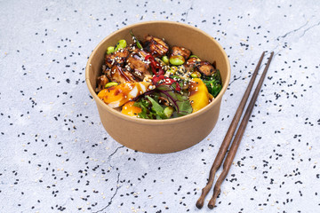 Poke bowl with chicken and vegetables on the white table.