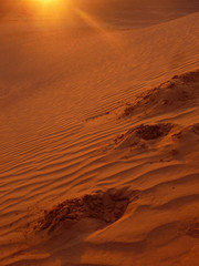 Sunset with footrpints in sand dune