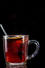 making tea from a tea bag in a transparent mug on a black background