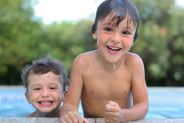 brothers playing in the pool, narrow focus