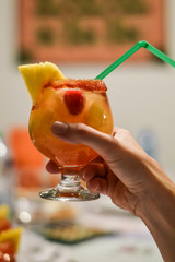 drinking a glass of pink sangria - pink sangria is wine based cocktail made with fruits and champagne wine instead of classic red wine