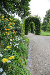 Vintage Garten und Landschaftsbau: Laubengang und mit Blumenbeeten gesäumter Fussweg in einem Park...