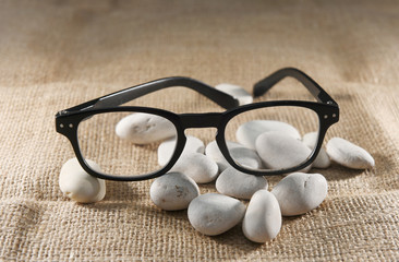 Fototapeta na wymiar glasses on a brown sack cloth between the stones