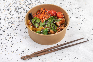 Poke bowl with chicken and vegetables on the white table.