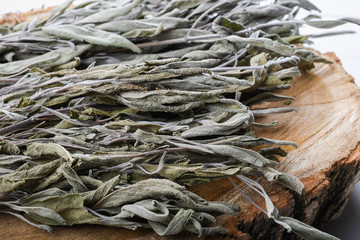 Dried sage branches, sage hot tea, on a piece of natural wood, natural remedies, natural medicine