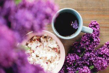 Obraz na płótnie Canvas granola with yogurt. healthy breakfast. purple lilac flowers. cup of coffee with lilac flowers