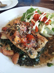 Delicious Fish Steak with Pesto Sauce and Vegetable Salad in White Dish