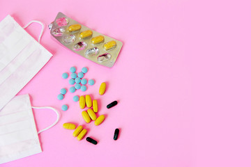 medical masks and tablets on a pink background